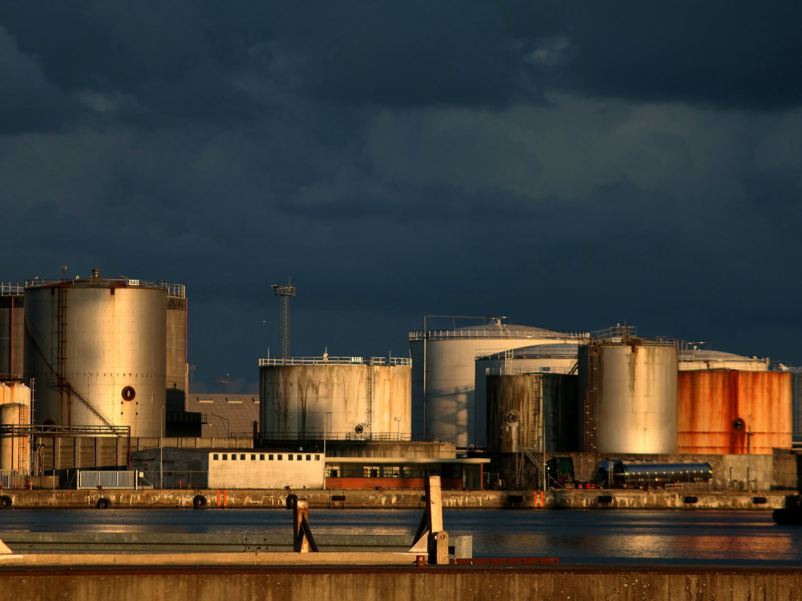 Fuel storage tank farm under a dramatic sky
